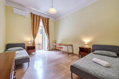 a room with two beds and a table and a window at Relax a Trastevere in Rome