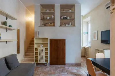 a small kitchen with wooden cabinets and a chair at GuestHost - Roma Tiburtina Apartment in Rome