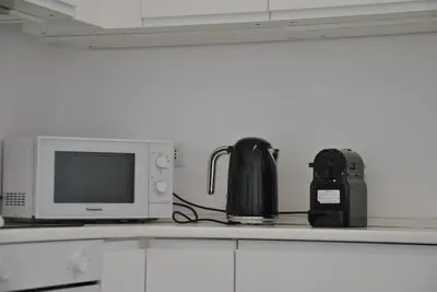 a kitchen counter with a microwave and a tea kettle at Giulio al MAXXI Apartment Flaminio in Rome