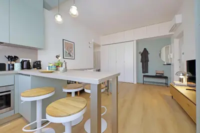 a kitchen with a table and stools in a room at YCH-Eleganza e confort vicino metro re di Roma in Rome