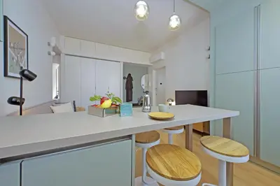 a kitchen with a white counter and stools at YCH-Eleganza e confort vicino metro re di Roma in Rome