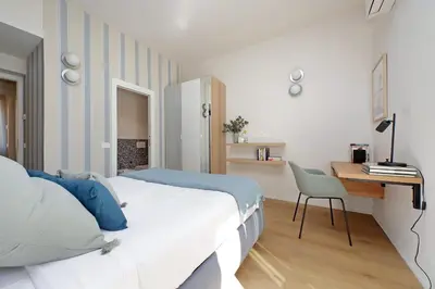 a bedroom with a bed and a desk and a chair at YCH-Eleganza e confort vicino metro re di Roma in Rome
