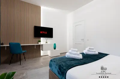 a bedroom with a bed and a desk and a tv at GFC Eternal Rome Apartment - 5min to Tiburtina Station MetroB, 2 Bathrooms, Terrace, A-C in Rome