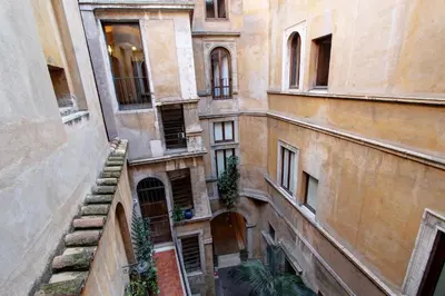 an alley with a palm tree in a building at Roma Centro Storico - Palazzo Avila '500 in Rome