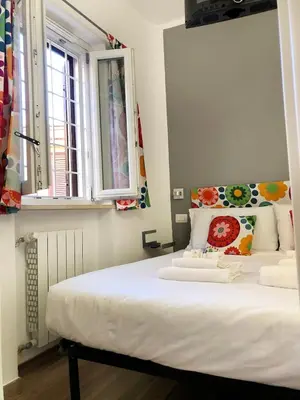 a bedroom with a large white bed with a window at Wonderful little gem with a large private terrace! in Rome