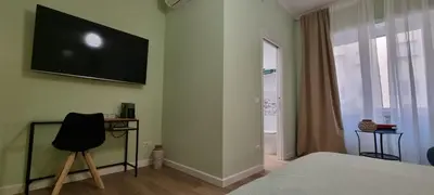 a bedroom with a bed and a television on the wall at Yuki Apartment in Rome