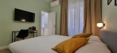 a bedroom with a bed and a television on the wall at Yuki Apartment in Rome