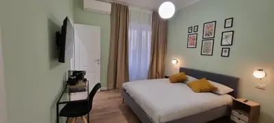 a bedroom with a bed and a desk with a television at Yuki Apartment in Rome