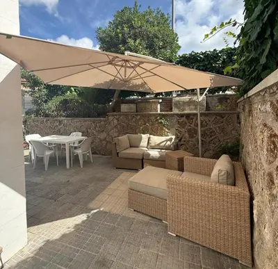 a patio with couches and a table and an umbrella at La Martinella a Roma in Rome