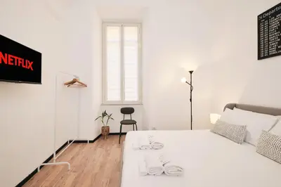 a white bedroom with a bed and a window at Termini Station 5 minutes - Free Wi-Fi & Netflix in Rome
