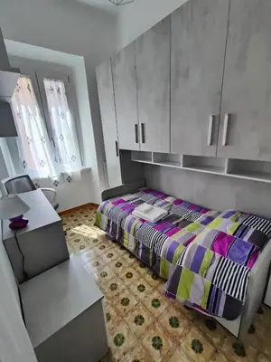 a bedroom with a bed and a desk and cabinets at Romein5minutes in Rome