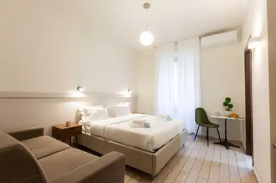 a bedroom with a bed and a chair and a couch at Renovated 2-bdr flat Statuto - ZEN 51 in Rome