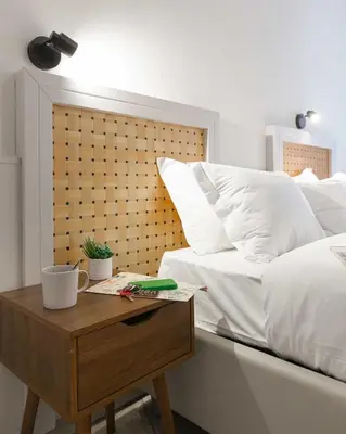 a bed with white pillows and a wooden table with a night stand at Renovated 2-bdr flat Statuto - ZEN 51 in Rome