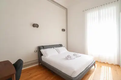 a bedroom with a bed with white sheets and a window at Lux San Pietro Apartment in Rome
