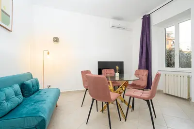 a living room with a couch and a table and chairs at San Pietro Apartment 66 in Rome