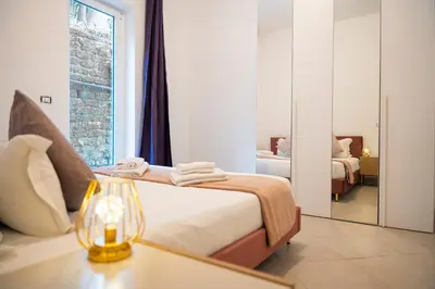 a bedroom with a bed and a table with a lamp at San Pietro Apartment 66 in Rome