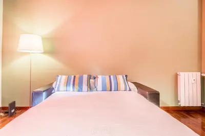 a bedroom with a large bed with a lamp at Casa Nina Ostiense - Roma Tre - by GHOR in Rome