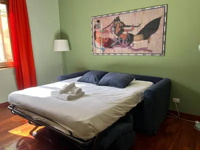 a bed in a room with a painting on the wall at Casa Nina Ostiense - Roma Tre - by GHOR in Rome