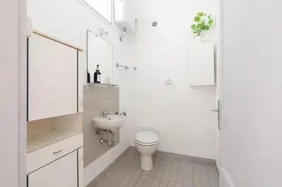 a white bathroom with a toilet and a sink at San Paolo Private Garden Home in Rome