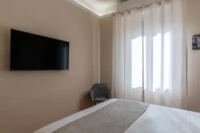 a bedroom with a bed and a television on the wall at GuestHost - AppioLatino Apartment Roma in Rome