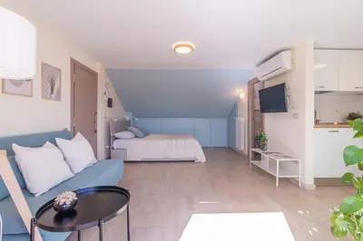 a living room with a blue couch and a bed at Luxury Maison Dei Colli in Rome