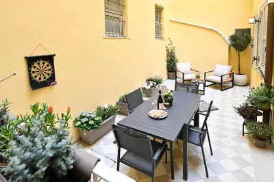 a patio with a table and chairs and potted plants at Monti luxury patio apartment in Rome