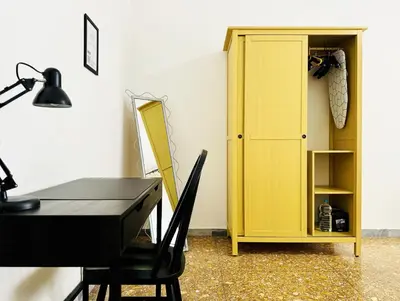 a yellow cabinet next to a table and a desk at Domus Bonadies - Musei Vaticani - San Pietro in Rome