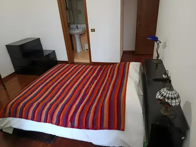 a bedroom with a bed with a colorful striped blanket at Milizie Vintage in Rome