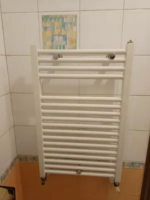 a white radiator in a bathroom with a tile wall at Milizie Vintage in Rome