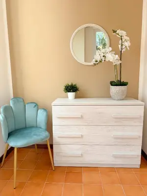 a dresser with a blue chair and a mirror at NEW! St Peter Roman holidays 1953 in Rome