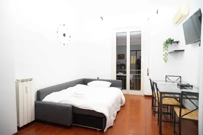 a bedroom with a bed and a desk and a table at Modern and Central One-Bedroom, 10 min from Colosseum in Rome