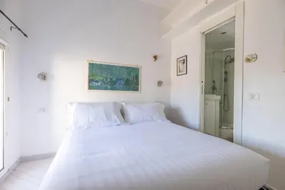 a white bed in a white bedroom with a mirror at Dante Secret Home in Rome