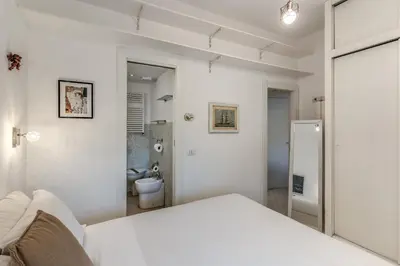 a white room with a bed and a bathroom at Dante Secret Home in Rome