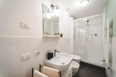 a white bathroom with a sink and a shower at Fancy Colosseum - Best location in Rome