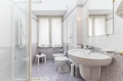 a white bathroom with a sink and a toilet at La Casetta Furio Camillo in Rome