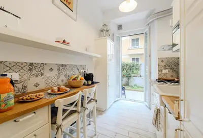 a kitchen with white cabinets and a counter with fruits on it at Toto Vatican Suite in Rome