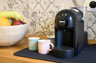 a coffee maker sitting on a counter with two coffee cups at Toto Vatican Suite in Rome