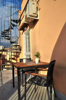 a table and chairs on a balcony with a window at Monti View Apartment in Rome