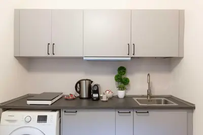 a kitchen with white cabinets and a sink at Rental in Rome Guest House 2-ZEN51 in Rome