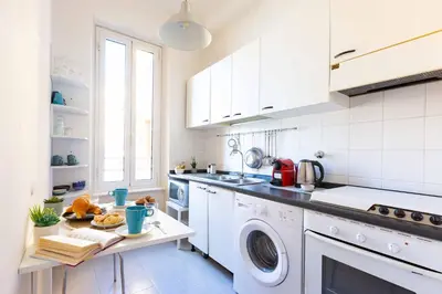 a white kitchen with a washer and dryer at Belle Arti Zen Apartment- Cale 03 in Rome
