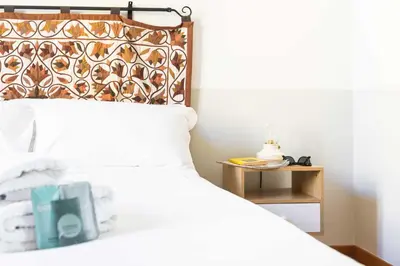 a bedroom with a white bed with a wooden headboard at Belle Arti Zen Apartment- Cale 03 in Rome