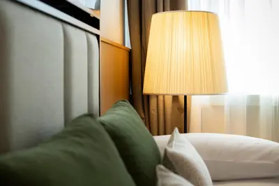 a lamp sitting next to a couch with a green pillow at Circle6 Rome in Rome