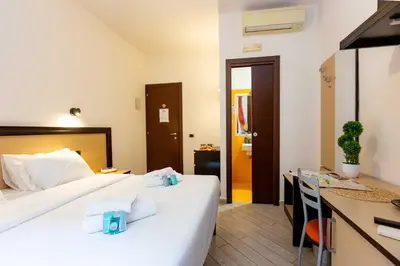 a hotel room with two beds and a desk at Rental in Rome Guest House - ZEN01 in Rome
