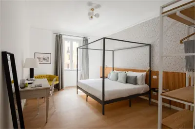 a bedroom with a canopy bed and a desk at Aeterna Suites Roma in Rome