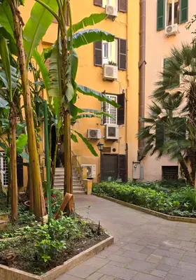 a building with palm trees in a courtyard at Aeterna Suites Roma in Rome