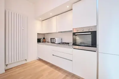 a white kitchen with white cabinets and appliances at Elegant Apartment near the Centre - Wi-Fi & Netflix Free in Rome