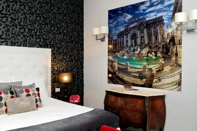 a bedroom with a bed and a painting on the wall at Sistina Twentythree luxury rooms in Rome