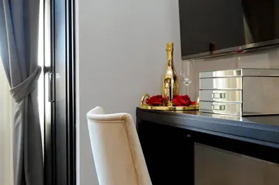 a kitchen with a counter with a bottle and a chair at Sistina Twentythree luxury rooms in Rome