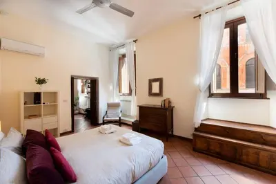 a bedroom with a large bed and a window at Secret place in the heart of ancient Trastevere in Rome