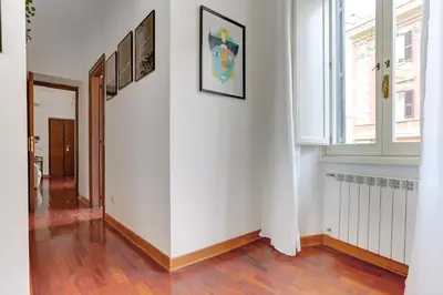 a hallway with white walls and a large window at Colosseo Green Park - Home and More in Rome